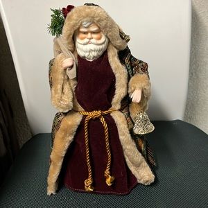 Santa dresses in velvet bearing gifts